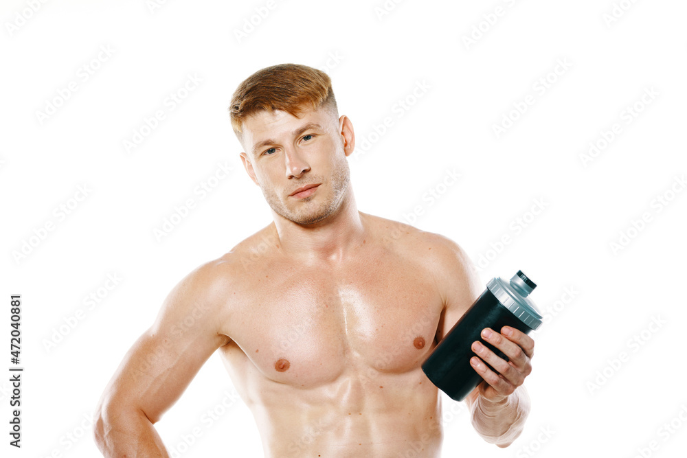 a man an athlete with a pumped-up body drinks from a bottle