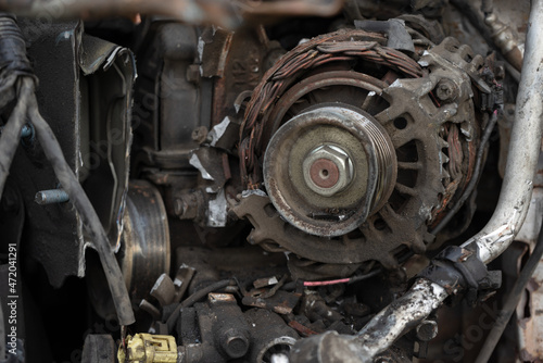 broken car generator. the old generator is on the engine of the car