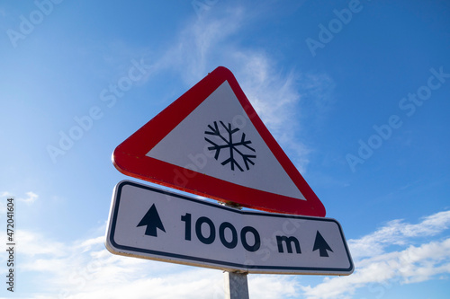 Señal de peligro de hielo en la carretera en el próximo kilómetro (quilómetro). 1.000 metros.