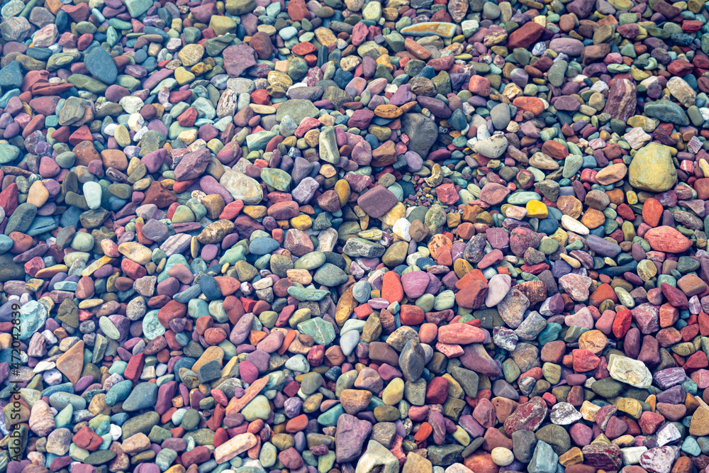 Colored stone pebbles and rocks in the crystal clear water Lake McDonald in Glacier National Park, Montana at sunset on a summer evening - near Columbia Falls/Kalispell/Whitefish/Hungry Horse