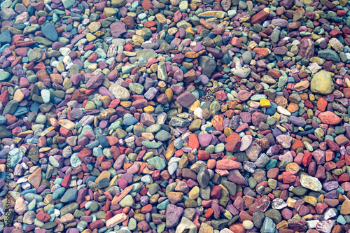 Colored stone pebbles and rocks in the crystal clear water Lake McDonald in Glacier National Park, Montana at sunset on a summer evening - near Columbia Falls/Kalispell/Whitefish/Hungry Horse photo