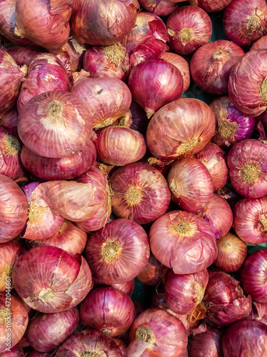 Pile of raw shallot with red shell in stall
