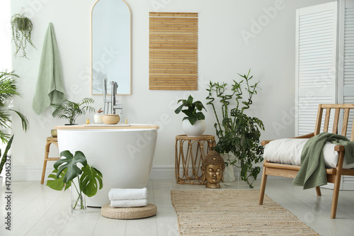 Stylish bathroom interior with modern tub  houseplants and beautiful decor. Home design