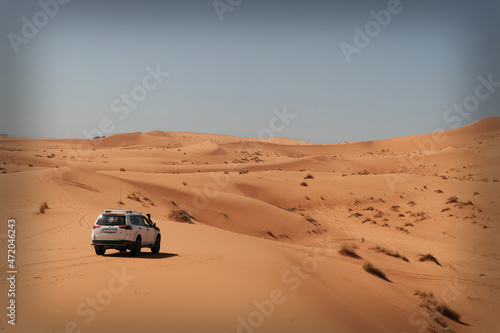 one car in the hot Sahara desert in the morning with no people