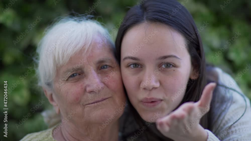 Happy senior woman with child enjoying a sunny day embracing outdoors, slow motion Happy senior woman with child enjoying a sunny day embracing outdoors, slow motion
