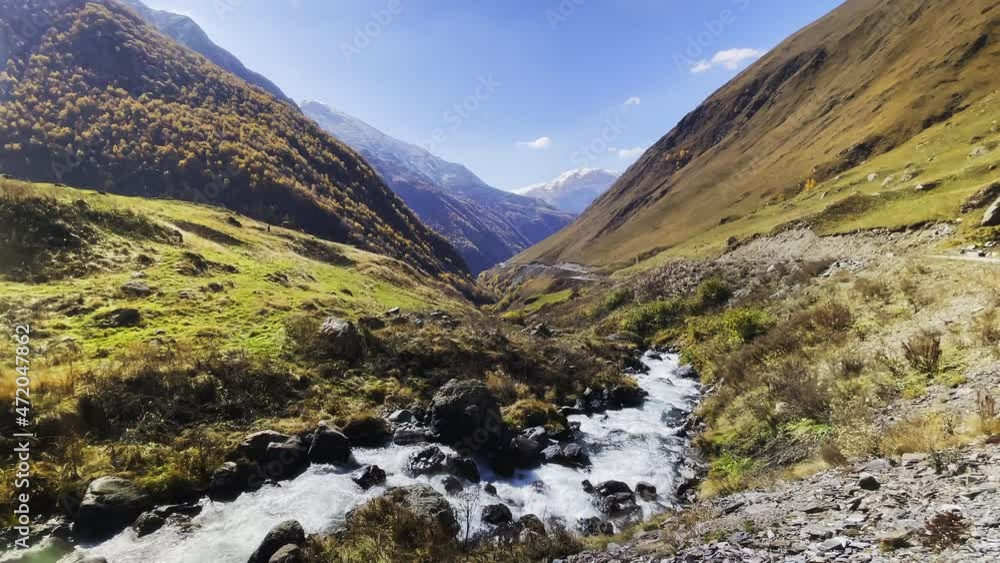 Fast creek in valley amidst mountains Fast creek in valley amidst mountains