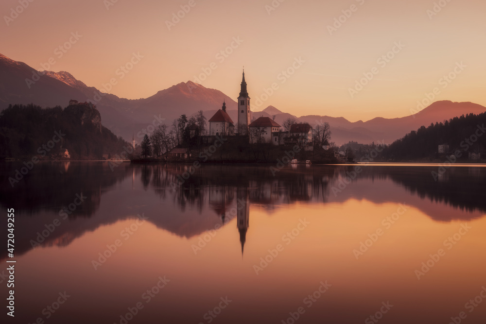 Picturesque sunrise on the lake Bled. Perfect reflection of the church in smooth water. Atmospheric mood. Nature background. The nature of Slovenia. Lake Bled.Parish Church of St. Martina. Europe