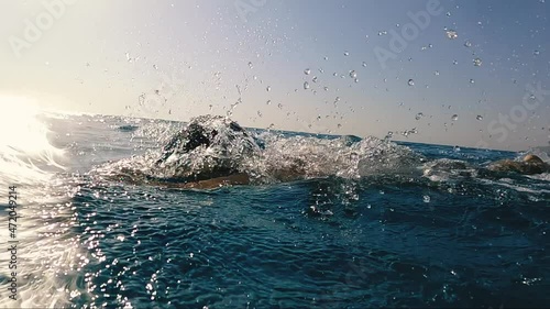 Stock video young professional triathlon swimmer athlete practicing at morning sea. open water swimming training. slow motion shot 