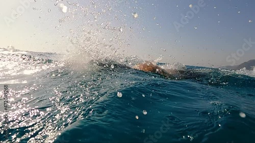 Stock video young professional triathlon swimmer athlete practicing at morning sea. open water swimming training. slow motion shot 