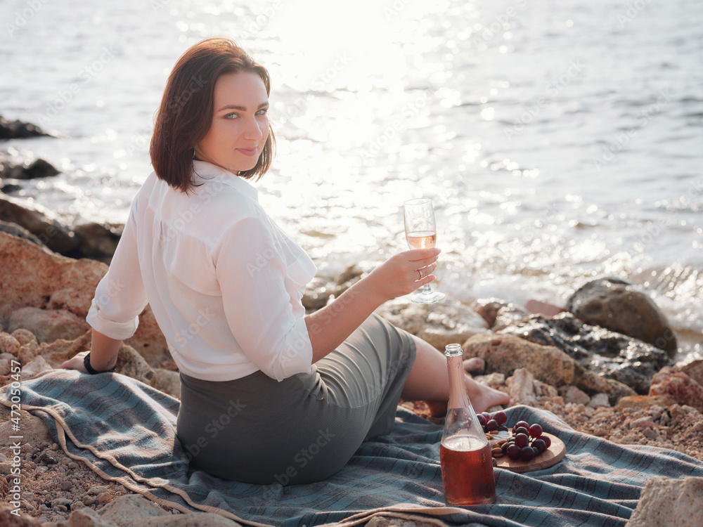 Φωτογραφία Happy young woman enjoy picnic with ocean view, sit on sea cliff drink rose wine