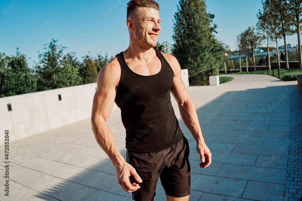Obraz premium athletic man with dumbbells in his hands in the park training lifestyle