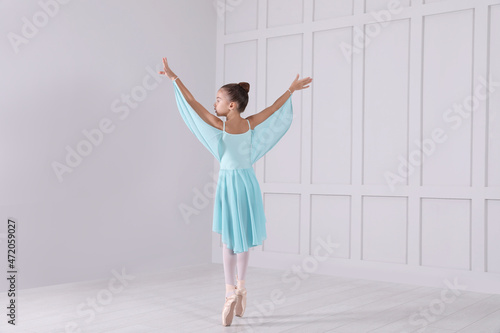 Fototapeta Naklejka Na Ścianę i Meble -  Beautifully dressed little ballerina dancing in studio