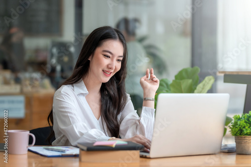 Portrait of smiling beautiful Asian businesswoman enjoy the idea sitting at office.