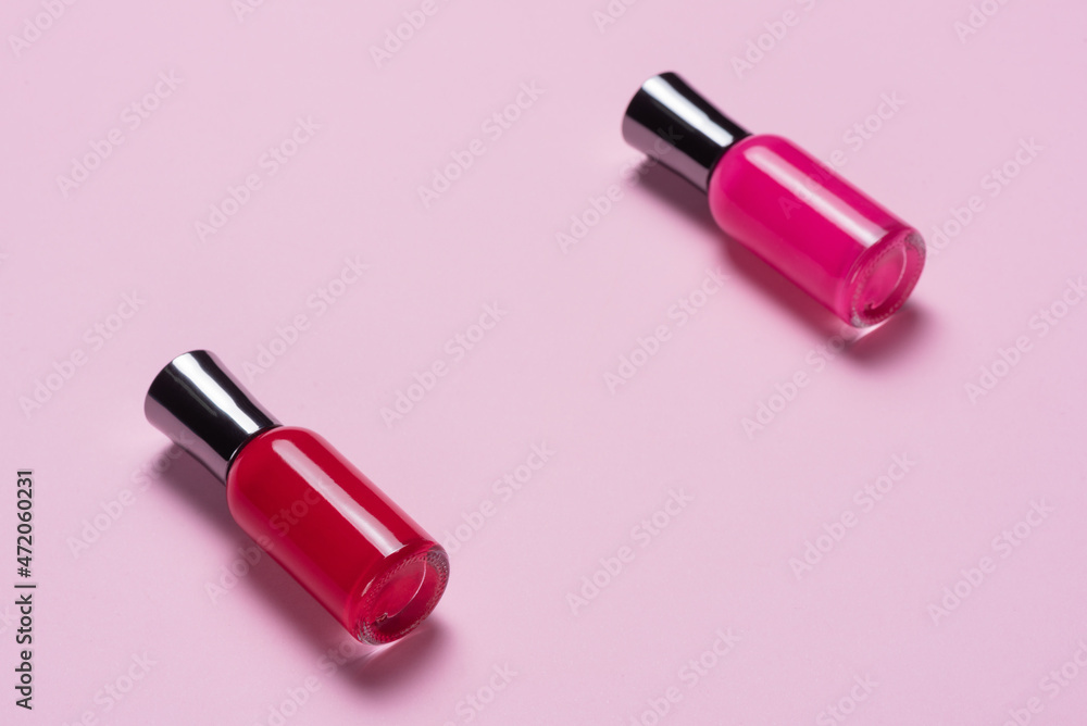 Two nail polish bottles on the pink top view background with copy space. Two nail polish bottles on the pink top view background with copy space.