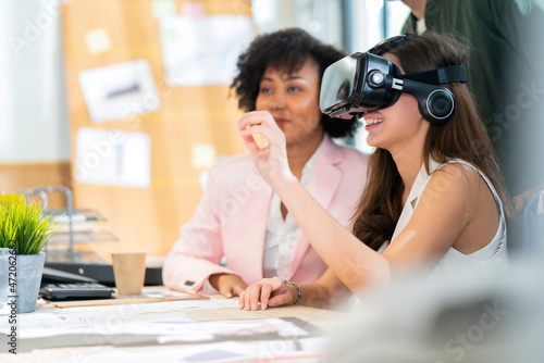 group of millennial male and female multiethnic using vr goggle to test metaverse meeting system cheerful and smiling,office friend standing discussion together next to window office background