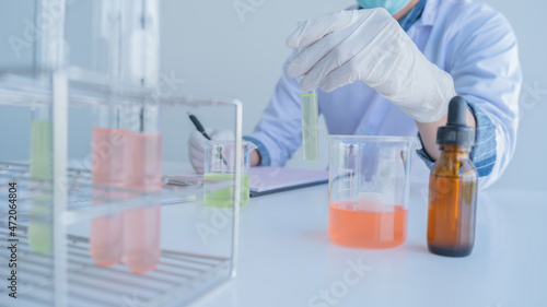 Medical or scientific researcher or man doctor looking at a test tube of clear solution in a laboratory