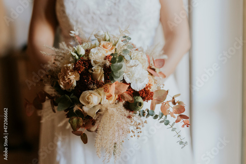 bride holding bouquet of autumnal flowers