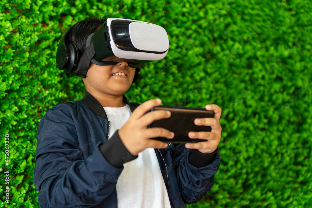 Young boy wearing vr goggle and headset playing games using smartphone Young boy wearing vr goggle and headset playing games using smartphone