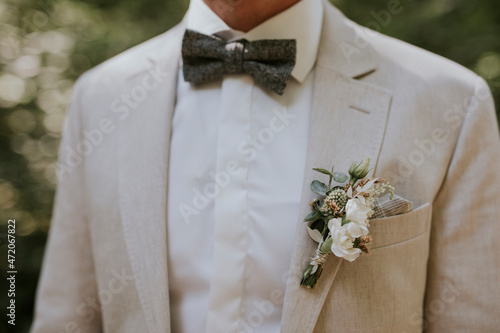 groom in a cream suit with a tie