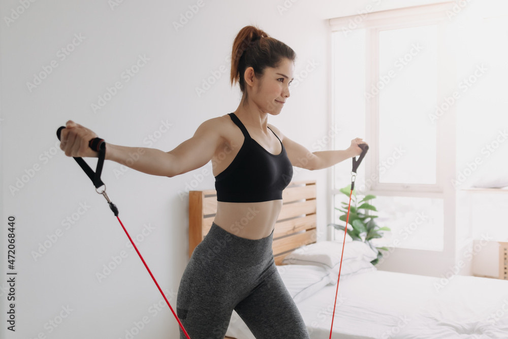 Asian woman do Resistance Band Upper Chest Press workout in her bedroom. Asian woman do Resistance Band Upper Chest Press workout in her bedroom.