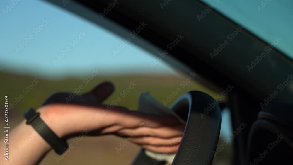 Wipe the steering wheel of the car with a damp cloth. CloseUp. Side view. SlowMo Wipe the steering wheel of the car with a damp cloth. CloseUp. Side view. SlowMo