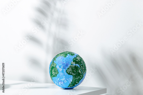 Small globe placed on white table in light room photo