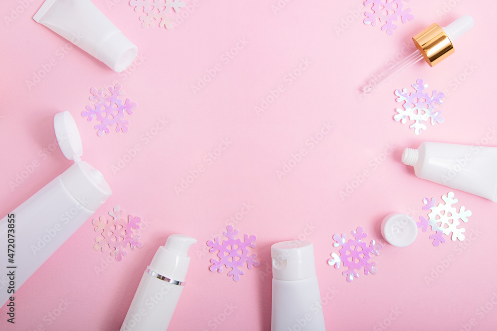 Top view of the cosmetics containers on pink background with negative space.Good for new year offer and text overlay. Top view of the cosmetics containers on pink background with negative space.Good for new year offer and text overlay.