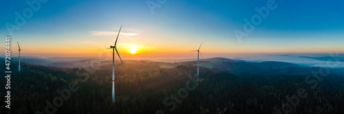 Aerial panorama of wind farm in forested Schurwald range at sunset