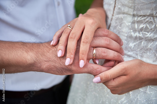 Newlywed couple's hands with wedding rings, copy space. Wedding couple, bride and groom, hands with rings, closeup