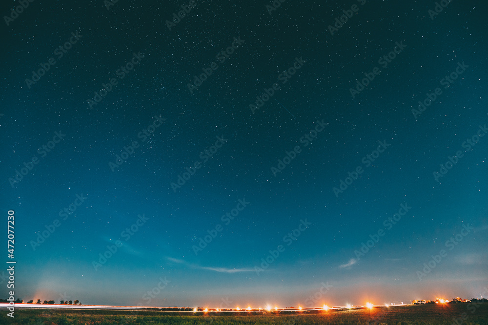 Night Starry Sky With Glowing Stars Above Landscape With City Lights. Night Starry Sky Above Ground. Copy Space