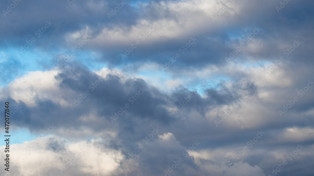 Fototapeta premium Dark heavy clouds in the blue sky, dramatic sky with dark storm clouds