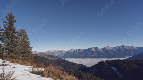 wonderful view in the morning with fog in the valley and blue sky on the mountains