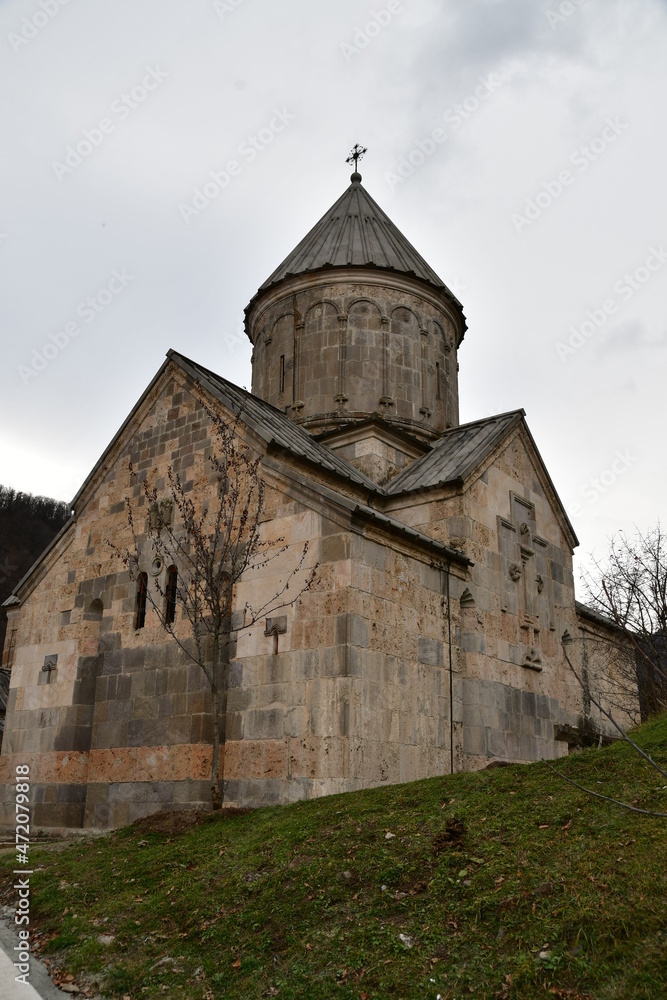 An old church with a conical roof. The church building is made of large stone blocks.