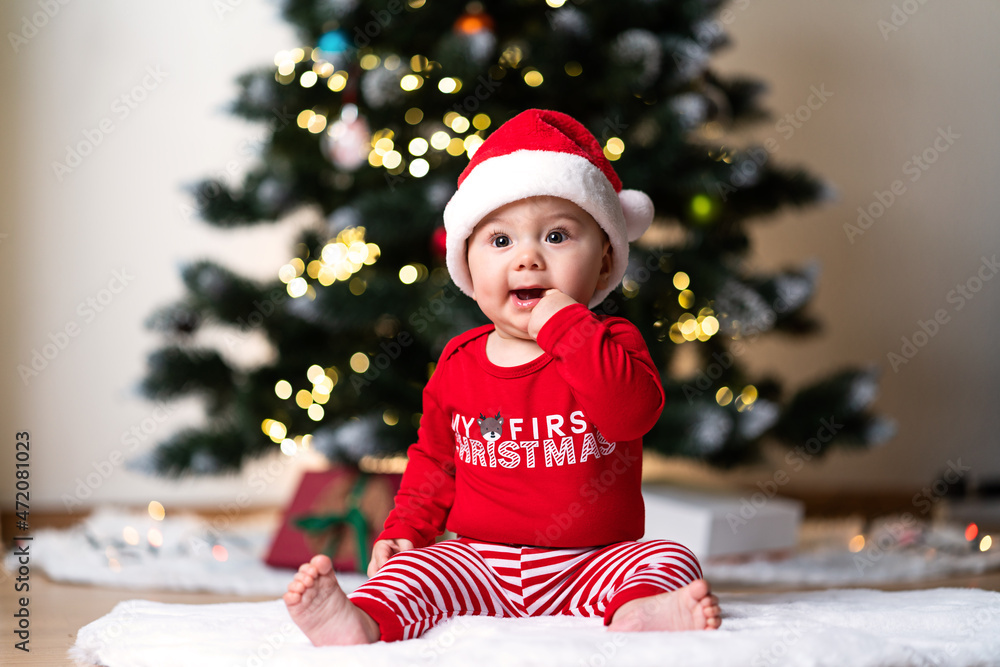 adorable little baby boy in a red christmas outfit sitting on a soft fake  fur in front of a christmas tree Stock-Foto | Adobe Stock