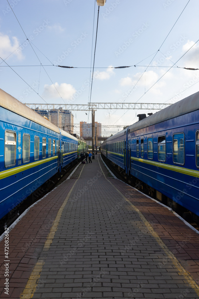 Odessa, Ukraine - 10|18|2020: A passenger train, a compartment carriage outside of a blue-and-blue color, stands on a pirone.