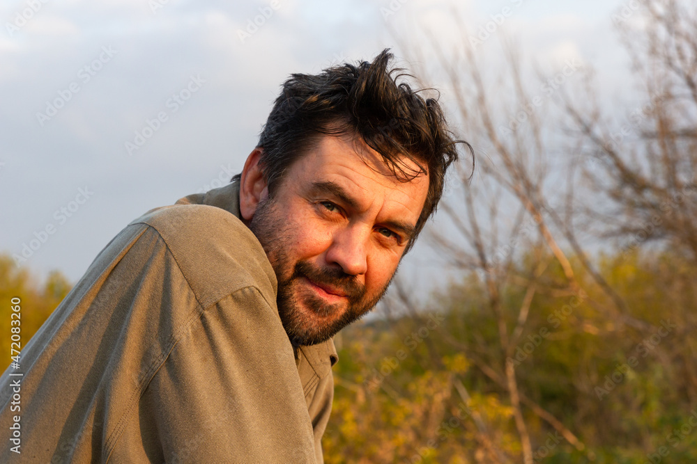 Portrait of an adult man with black hair and a beard on the street. Portrait of an adult man with black hair and a beard on the street.