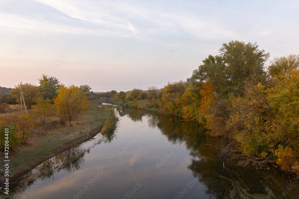 autumn landscape with a view of the river at sunset. Trees along the banks with colorful leaves autumn landscape with a view of the river at sunset. Trees along the banks with colorful leaves