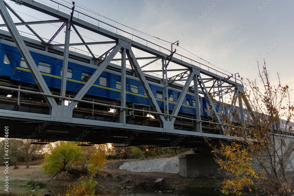 Fototapeta premium railroad and railway bridge and a passing passenger train