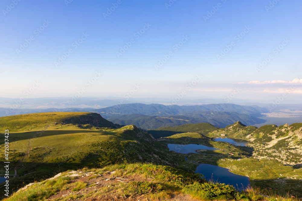 On the top of the mountains, landscape on green mountains and mountain lakes, above the clouds at sunset