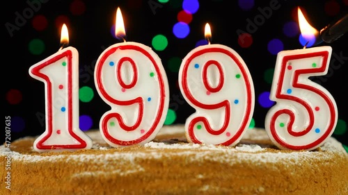 Birthday cake with white burning candles in the form of number 1995