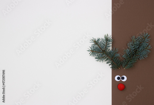 Decorative deer muzzle with horns made of coniferous branches, the basis for a greeting card for Christmas and new Year