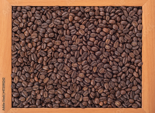 Coffee beans in a wooden frame  abstract background.