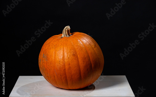 M?lndal, Sweden - October 23 2021: Pumpkin on a white table against black backdrop. photo