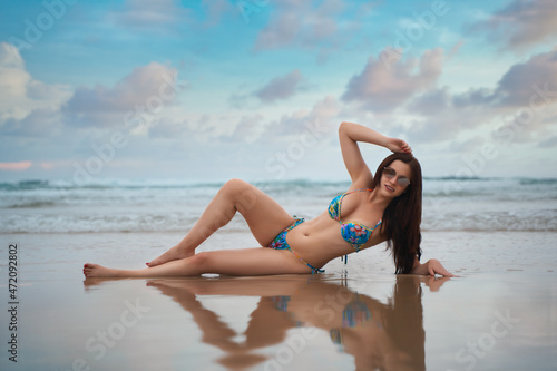 Young beautiful female fit model pose in the colorful bikini at Karon Beach Phuket Thailand