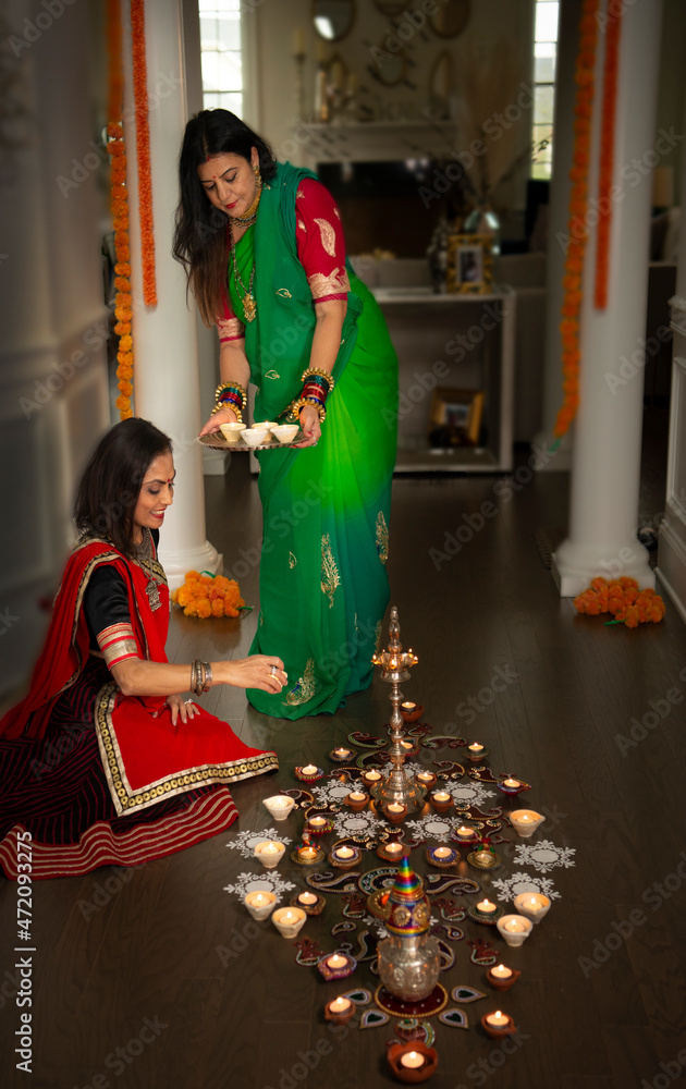 Women arranging Diwali lamps 