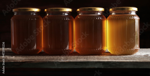 Barattoli di miele isolati su sfondo scuro. photo