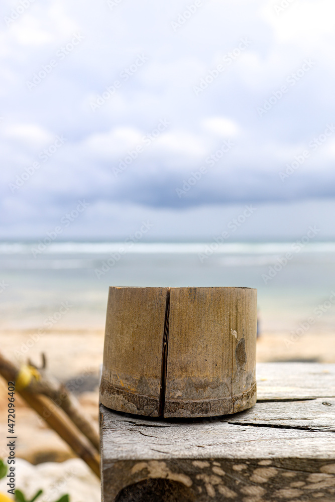 Naklejka premium bamboo cup at a wooden table at the beach