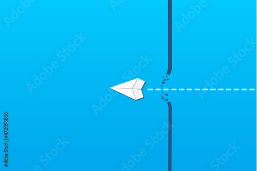 Concept of overcoming barriers on the way to goal, target, with white paper airplane breaking through obstacle on blue background.