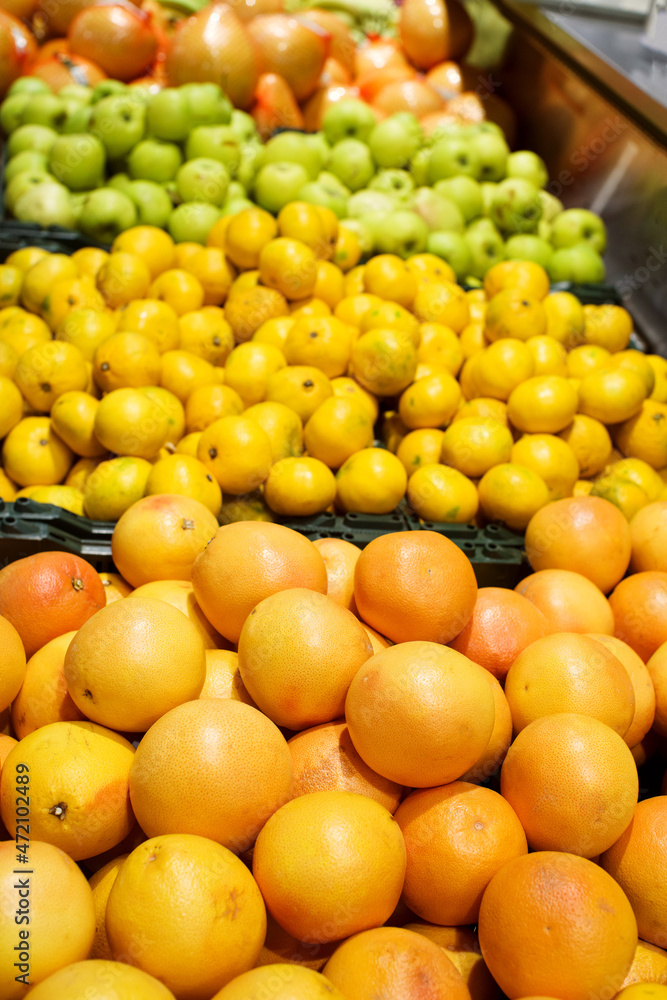 Grapefruit, lemons, apples and other fruits on the counter in the hypermarket