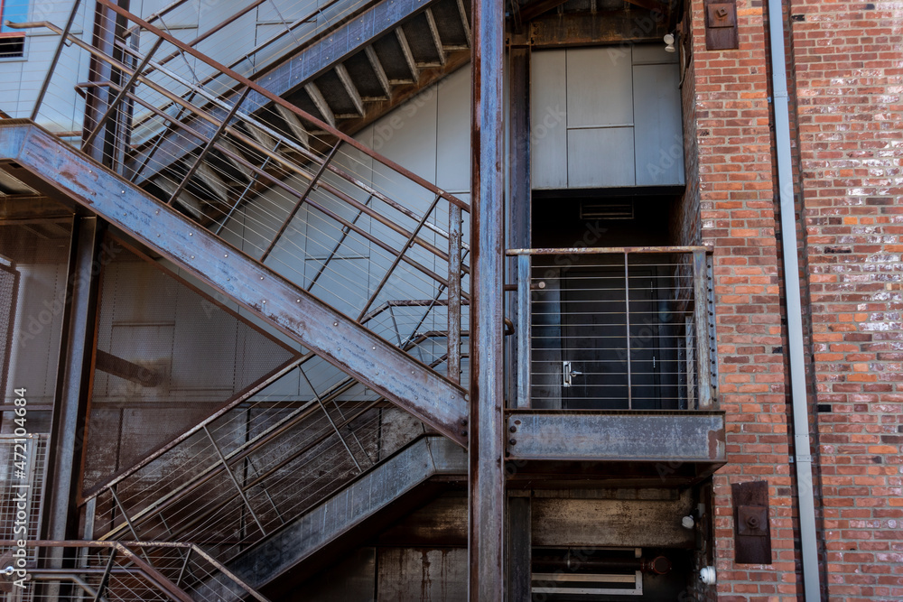 Low angle view of a fire escape outside of a brick building in downtown Tacoma, WA - obrazy, fototapety, plakaty 